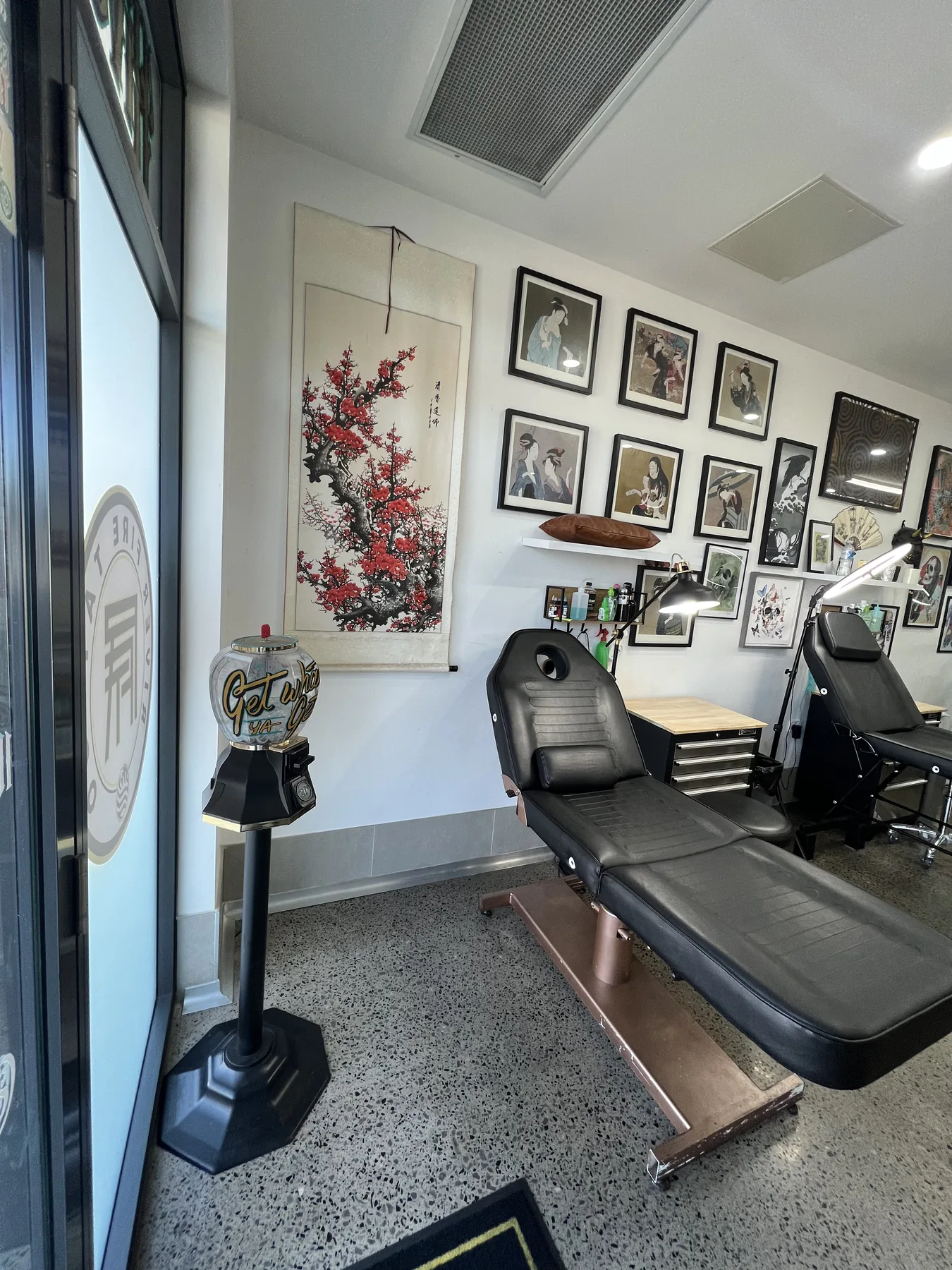 Front tattoo bay at River Fire Tattoo, with the door emblem and studio artwork